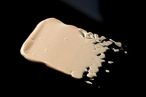 The texture of a foundation liquid. Black background. Stock Photos