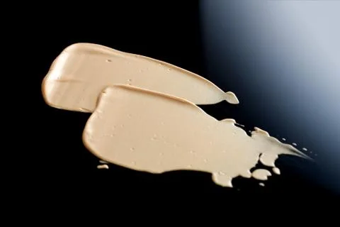 The texture of a foundation liquid. Black background. Stock Photos