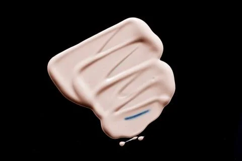 The texture of a foundation liquid. Black background. Stock Photos