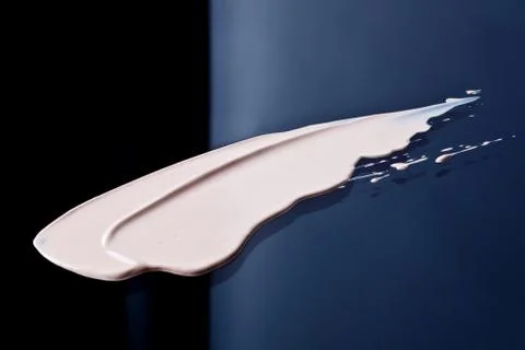 The texture of a foundation liquid. Black background. Stock Photos