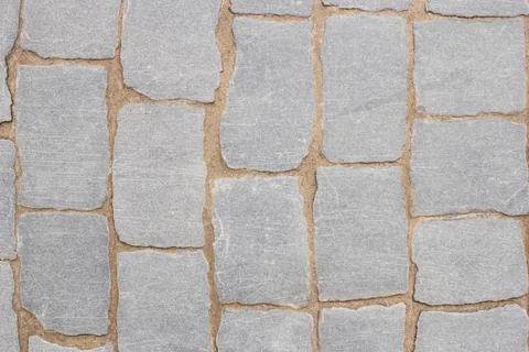 Texture of fragment of gray path made of masonry with sand in seams between p Stock Photos