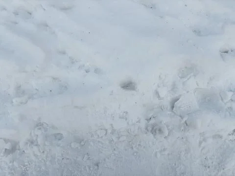 Texture of freshly fallen snow with light traces and lumps of ice on the surface Stock Photos