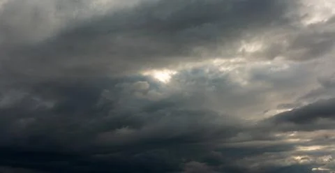 The texture of a gloomy cloud against the background of the penetrating sun b Stock Photos