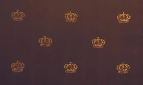Texture of the golden crown pattern on a red velvet canvas. royal symbols clo Stock Photos