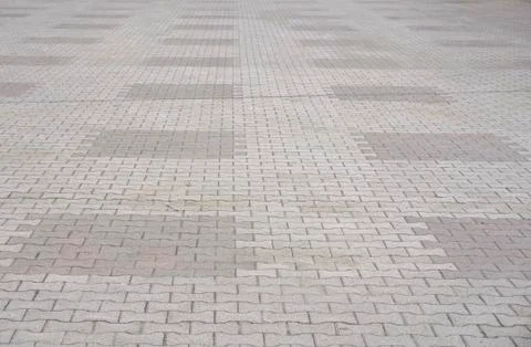 Texture of gray and yellow patterned paving tiles on the ground of street, pe Stock Photos
