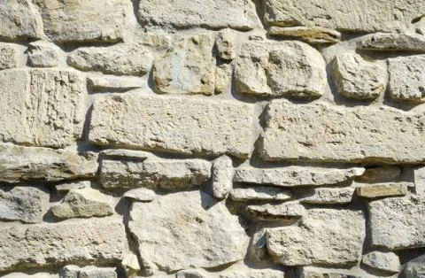 The texture of the historic stone wall of light yellow color Stock Photos
