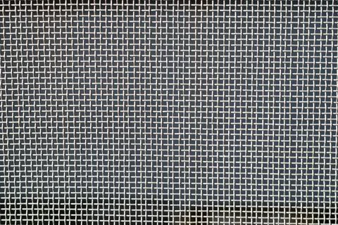 Texture of interwoven metal threads. Stainless steel wire is woven perpendicu Stock Photos