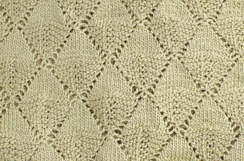 The texture of knitting with rhombuses. Beige background Stock Photos