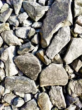 Texture of large stony rubble in different shades of gray with patches of yel Stock Photos
