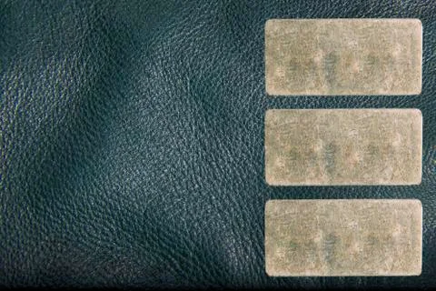 Texture of a leather jacket with three small rectangular metal label for your Stockfoto's