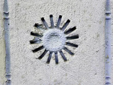 Texture of light clay in the form of the sun on the old light wall of the house Stock Photos