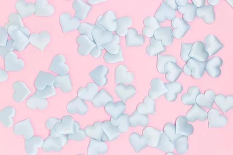 Texture made of blue textile confetti in a heart shape on a pink background. Stock Photos