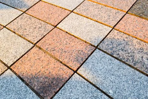 Texture of marble rectangular stone granite tiles with seams on the road. The Foto stock