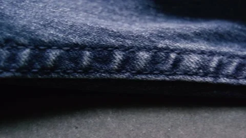 Texture of the material from the color of dark blue jeans with patches Stock Footage 130885306