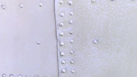 The texture of metal plates connected by rivets. Close-up of old metal, riveted  Video stock 155780579