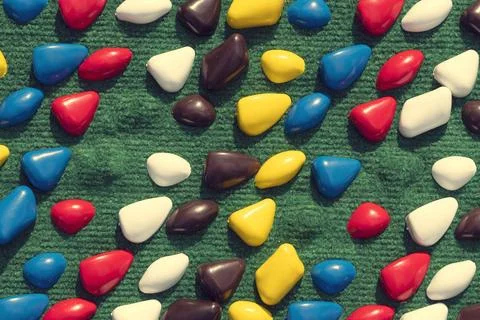 Texture with multi-colored stones. objects of different colors on a green b.. Stock Photos