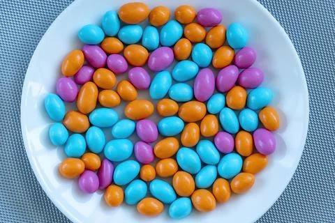 Texture with multi-colored stones on a white plate. objects of different co.. Stock Photos