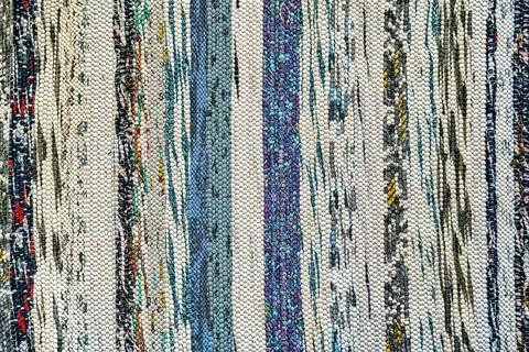 Texture of a multi-colored wicker floor carpet close-up. Abstract background. Stock Photos