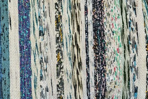 Texture of a multi-colored wicker floor carpet close-up. Abstract background. Stock Photos