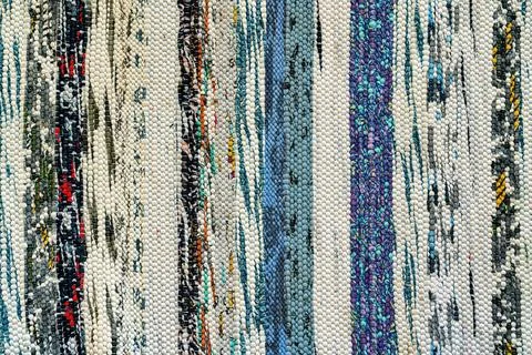 Texture of a multi-colored wicker floor carpet close-up. Abstract background. Stock Photos