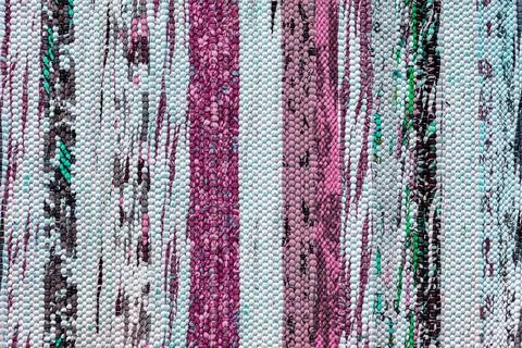 Texture of a multi-colored wicker floor carpet close-up. Abstract background. Stock Photos