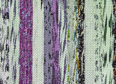 Texture of a multi-colored wicker floor carpet close-up. Abstract background. Stock Photos