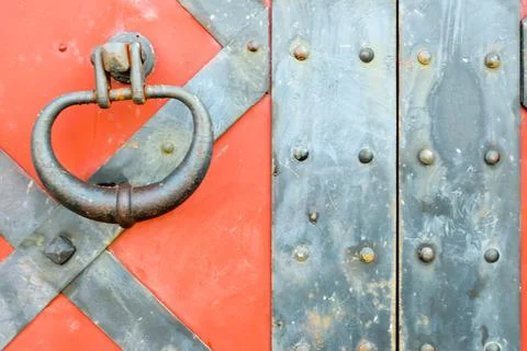 Texture of an old ancient medieval red antique sturdy iron metal door with ri Photos