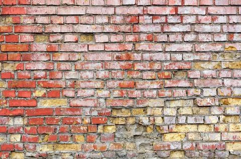 The texture of an old brick wall made of red bricks is spattered with paint w Stock Photos