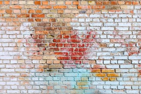 The texture of the old brick wall painted of blue, red, yellow a Stock Photos