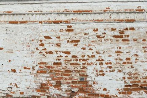 The texture of the old brick wall painted white with peeling paint Stock Photos