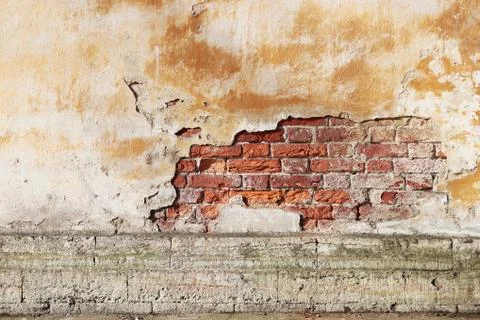The texture of the old bricks and beige plaster of the historic house. Stock Photos