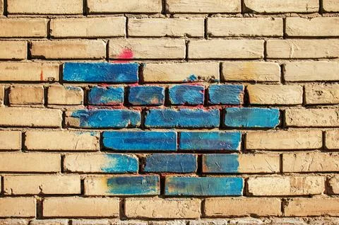 Texture of old colored bricks. Close-up of a red and green brick wall with paint Stock Photos