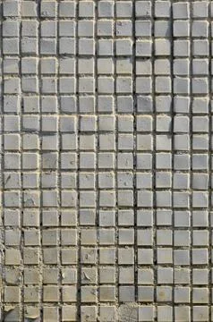 The texture of the old concrete wall, with a coating of shallow tiles of squa Stock Photos