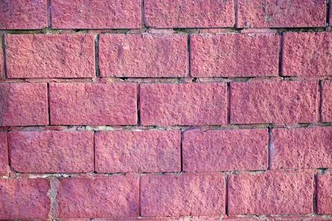 The texture of an old red brick stone wall with scuffs and scratches, painted Foto stock