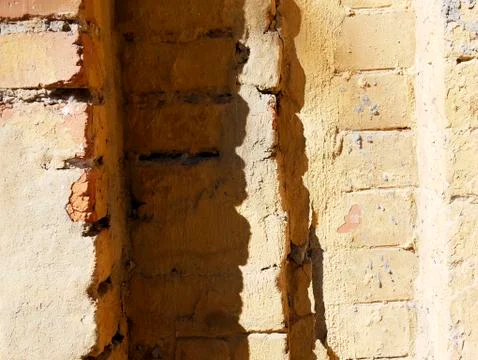 Texture of an old red-brown brick wall with shadows of solar lighting Stock Photos