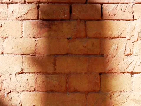 Texture of an old red-brown brick wall with shadows of solar lighting Stock Photos