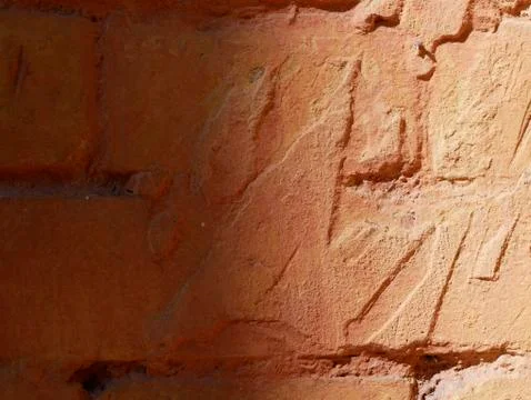 Texture of an old red-brown brick wall with shadows of solar lighting Stock Photos