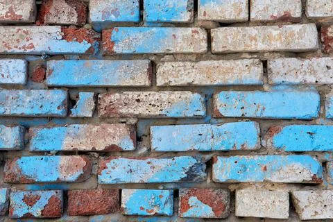 The texture of an old red, white and blue brick wall. Close-up, pattern. Stock Photos