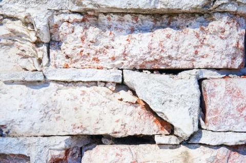 Texture of old rustic red brick wall painted with white. Close-up. Stock Photos