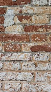Texture of an old rustic red brick wall with peeling white paint and weathered Stock Photos