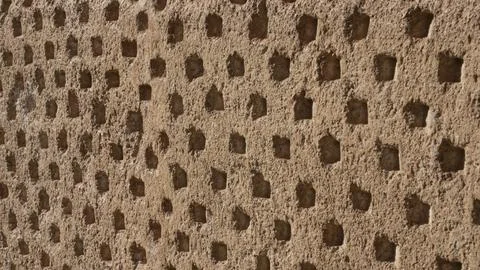 Texture of an old stone wall with small repetitive orifices Stock Photos