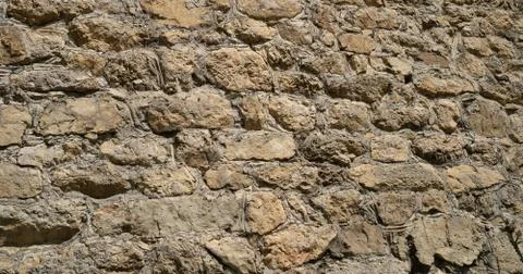 Texture of old stones of various forms with seams. Close up of shabby masonry Stock Photos
