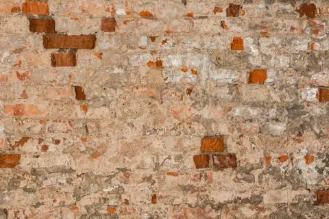 Texture of an old wall of an ancient building with a ruined plaster layer and Fotos de archivo