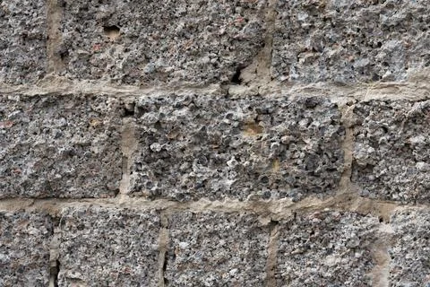 The texture of the old wall from a cement block. Rough gray surface. Concrete Stock Photos