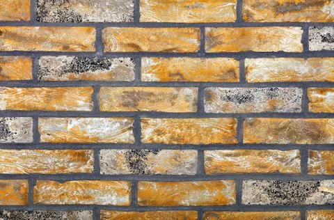 The texture of the old wall is lined with straight rows of old bricks and wor Stock Photos