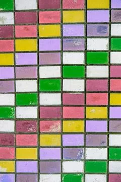 Texture of old wall tiles with peeling bright paint. colorful old shabby tile Stock Photos