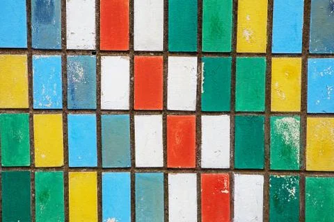Texture of old wall tiles with peeling bright paint. colorful old shabby tile Stock Photos