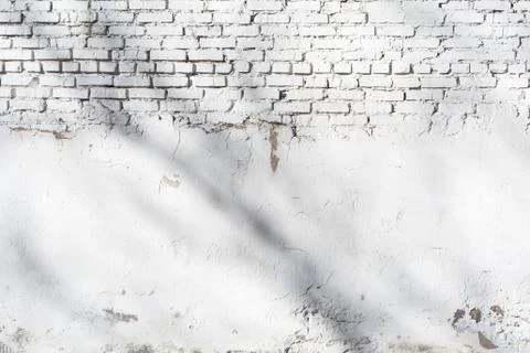 Texture of old white brick wall with destroyed plaster layer and shadows from Stock Photos