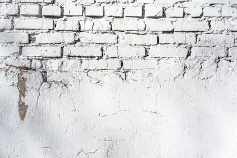 Texture of old white brick wall with destroyed plaster layer and shadows from Stock Photos