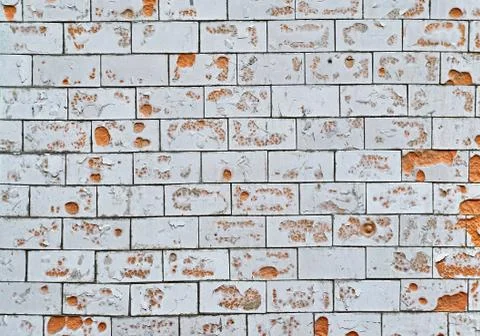 The texture of an old white, tiled wall with broken, cracked wall tiles. Back Foto stock